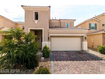 Charming two-story home featuring a brick driveway, well-manicured lawn and attached two-car garage at 6412 Dimatteo St, Las Vegas, NV 89148