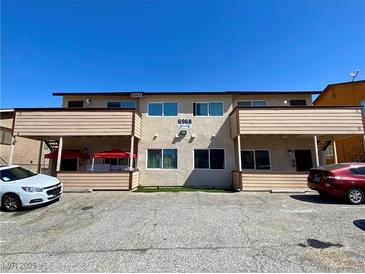A two-story apartment complex with a parking area in front and an awning on the ground level deck at 6968 Hopkins Dr, Las Vegas, NV 89156