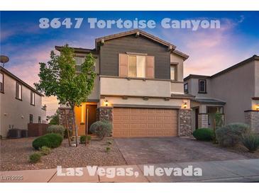 Charming two-story home with a two car garage, stone accents, and landscaped front yard at 8647 Tortoise Canyon Ct, Las Vegas, NV 89148