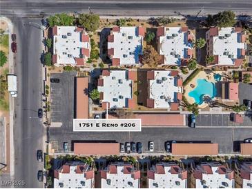 An aerial view showcases the community, parking, landscaping, and pool at 1751 E Reno #206 at 1751 E Reno Ave # 206, Las Vegas, NV 89119