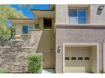 Two-story home with attached garage and stacked stone detail on front at 701 Peachy Canyon Cir # 201, Las Vegas, NV 89144