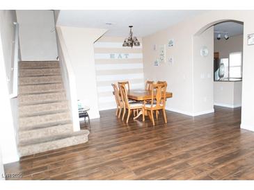 Inviting dining room features wood floors, a striped accent wall, and a traditional wood dining set, perfect for Gathering meals at 9303 Gilcrease Ave # 1077, Las Vegas, NV 89149