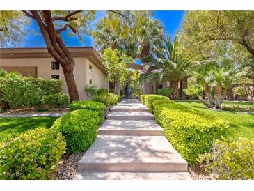 Beautiful walkway leading to a private residence with lush landscaping and mature trees at 9713 Highridge Dr, Las Vegas, NV 89134