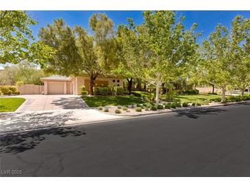 Charming single-story home features a well-manicured lawn and a two-car garage with mature landscaping at 9713 Highridge Dr, Las Vegas, NV 89134