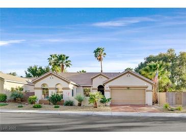 Charming single-story home with desert landscaping, mature palm trees and an attached two-car garage at 2309 Tedesca Dr, Henderson, NV 89052