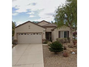 Charming single-story home with a two-car garage and desert landscaping in front yard at 2560 Crater Rock St, Henderson, NV 89044