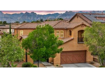 Charming two-story home with a two-car garage, terracotta tile roof, desert landscaping and mountain views at 617 Apricot Rose Pl, Las Vegas, NV 89138