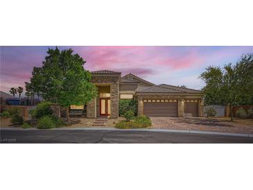 Beautiful single-story home featuring a three-car garage, manicured landscaping, and a welcoming stone facade at 7418 Lawrence Powers Ct, Las Vegas, NV 89129