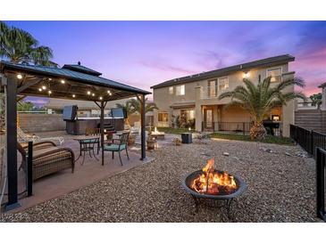 Outdoor living with a gazebo, fire pit, and hot tub for relaxation and entertaining in the landscaped backyard at 8208 Fritzen Ave, Las Vegas, NV 89131