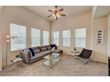 Bright living room boasts multiple windows, plush seating, ceiling fan and contemporary decor at 10001 Peace Way # 2231, Las Vegas, NV 89147