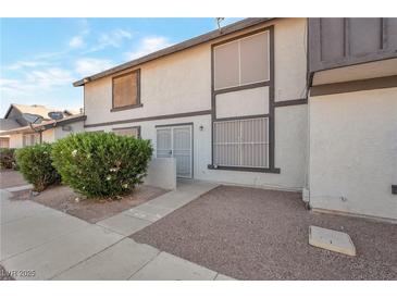 Two-story townhouse with neutral stucco exterior, security door, and low-maintenance landscaping at 3164 Richford Pl, Las Vegas, NV 89102