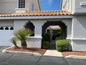 Inviting courtyard entrance with lush landscaping and tile roof at 5201 S Torrey Pines Dr # 1253, Las Vegas, NV 89118