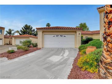 Charming single-story home featuring a two-car garage, tile roof, and attractive landscaping at 5373 Painted Mirage Rd, Las Vegas, NV 89149