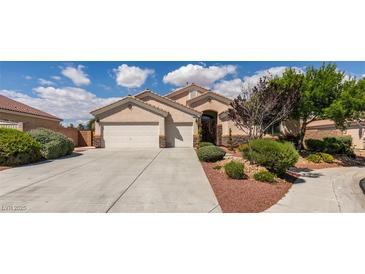 Charming single story home with a three car garage, desert landscaping, and a tile roof under sunny blue skies at 8204 Turbys Treehouse Pl, Las Vegas, NV 89131