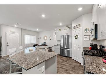 A modern, open-concept kitchen featuring granite countertops and stainless steel appliances at 4650 Ridgeley Ave # 103, North Las Vegas, NV 89084