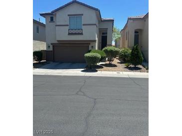 Two-story home featuring a two-car garage and manicured landscaping at 7047 Sombra Way, Las Vegas, NV 89113