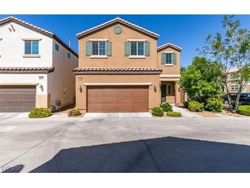 Two-story tan home featuring a two-car garage, neutral landscaping and a tile roof at 7609 Aubusson Ct, Las Vegas, NV 89149