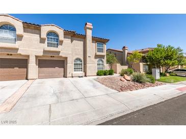 Inviting townhome with a two-car garage and desert landscaping for low maintenance appeal at 7732 Almeria Ave, Las Vegas, NV 89128
