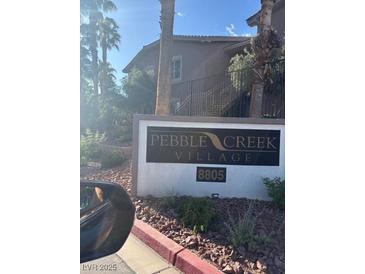 Pebble Creek Village community sign with address amid palm trees at 8805 Jeffreys St # 1112, Las Vegas, NV 89123