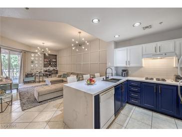 Open-concept kitchen with blue and white cabinets, complemented by a spacious living area at 91 E Agate Ave # 204, Las Vegas, NV 89123