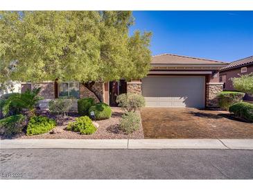 Charming single-story home featuring a two-car garage, stone accents, and mature landscaping at 936 Viscanio Pl, Las Vegas, NV 89138