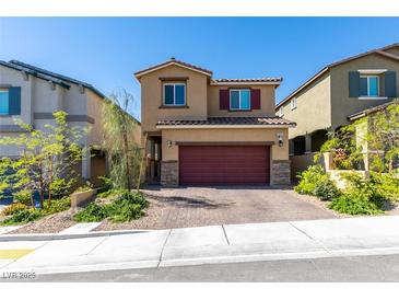 Charming two-story home featuring a red garage door, desert landscaping, and a brick-paved driveway at 10939 Cheshire Woods Ave, Las Vegas, NV 89166