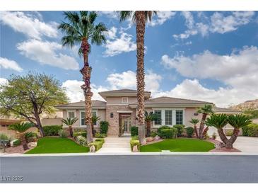 Charming single-story home featuring lush landscaping with beautiful palm trees and manicured greenery at 11527 Morning Grove Dr, Las Vegas, NV 89135