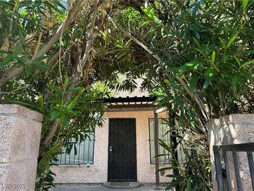 Charming front entrance with a security door and lush greenery surrounding the entry at 4338 Caliente St # 8, Las Vegas, NV 89119