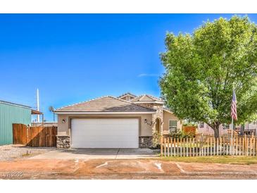 Charming single-story home featuring a two-car garage, neat landscaping and a quaint wooden fence at 474 Adelle Ave, Overton, NV 89040
