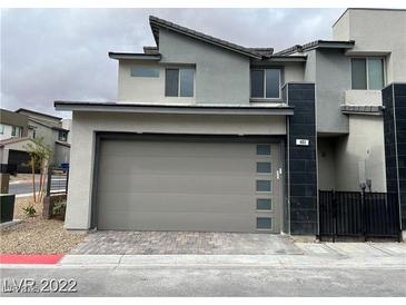 Contemporary two-story home featuring a modern gray facade, a two-car garage, and sleek architectural details at 483 Fairview Hills St, Las Vegas, NV 89138