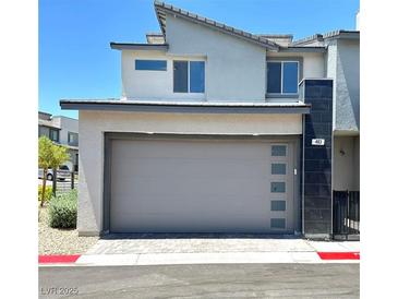 Modern two-car garage with gray door and brick-paved driveway on a sunny day at 483 Fairview Hills St, Las Vegas, NV 89138