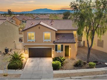 Charming two-story home with a tile roof, lush landscaping, and attached two-car garage on a sunny day at 1813 Arch Stone Ave, North Las Vegas, NV 89031