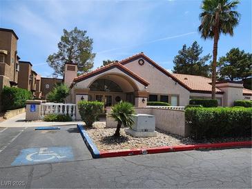 A view of the exterior of a community clubhouse with ample parking and landscaping at 2974 Juniper Hills Blvd # 104, Las Vegas, NV 89142