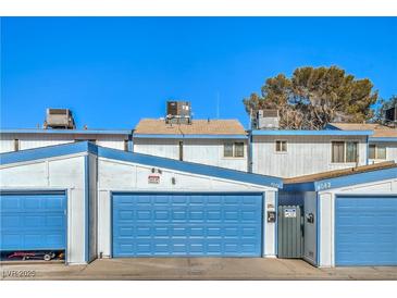 Exterior showing blue garages with white trim under a clear sky at 4078 Gold Coast Dr, Las Vegas, NV 89121