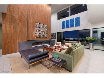 Elegant living room featuring a fireplace, high ceilings, and sophisticated decor with city views at 609 Sleeping Dragon Dr, Henderson, NV 89012