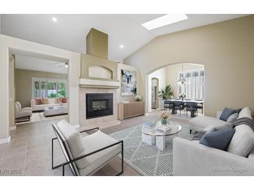 Bright living room with fireplace, neutral colors, vaulted ceiling, and skylight at 8541 Highland View Ave, Las Vegas, NV 89145