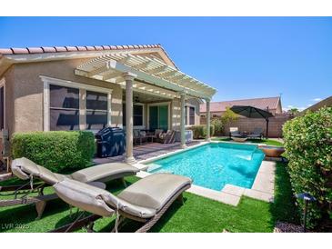 Beautiful backyard featuring a sparkling pool, lounge chairs, and a covered patio perfect for entertaining at 1081 Via Gandalfi, Henderson, NV 89011