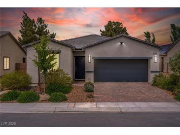 Charming single-story home featuring a two-car garage, brick driveway, and well-manicured landscaping at 4356 E Cactus Canyon Dr, Pahrump, NV 89061