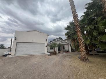 Quaint one-story home featuring a two-car garage and mature trees in a desert landscape at 4425 Sunflower Ave, Las Vegas, NV 89120