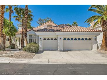 Beautiful single-story home showcasing a three-car garage, complemented by lush palm trees and attractive landscaping at 8124 Bay Harbor Dr, Las Vegas, NV 89128