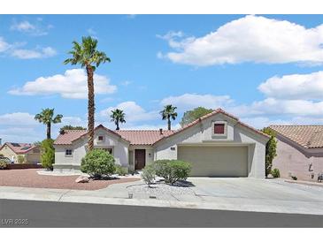 Charming single-story home with a two-car garage, desert landscaping, and mature palm trees at 9552 Gold Bank Dr, Las Vegas, NV 89134