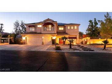 Inviting two-story home featuring a three-car garage, landscaped front yard, and warm exterior lighting at , Las Vegas, NV 89131