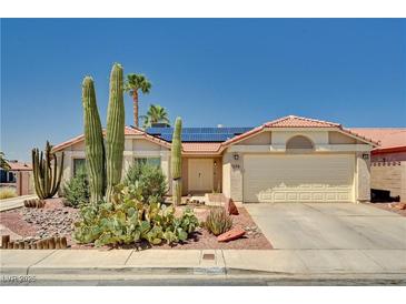 Charming single-story home with desert landscaping, tile roof and solar panels on a sunny day at 1536 Leatherleaf Dr, Las Vegas, NV 89123