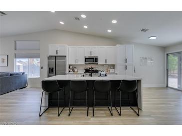 Bright kitchen featuring a large island with seating, stainless steel appliances, and lots of cabinet space at 1673 Golden Vista Dr, Las Vegas, NV 89123