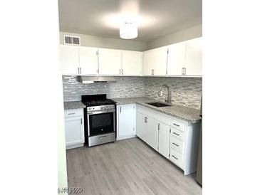 Updated kitchen featuring white cabinets, stainless steel appliances, and granite countertops at 212 Orland St # 22, Las Vegas, NV 89107