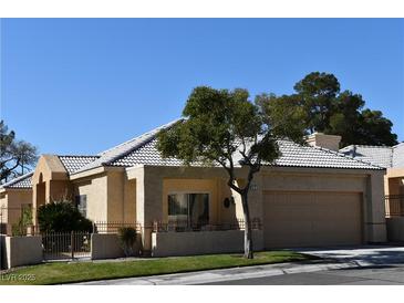 Charming single-story home with a well-manicured lawn, desert landscaping, and a two car garage at 325 Wild Plum Ln, Las Vegas, NV 89107