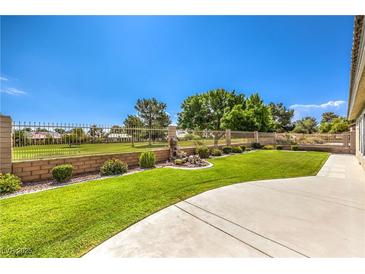 Expansive backyard featuring lush lawn, mature trees and privacy fence at 5000 Linkside Dr, Las Vegas, NV 89130