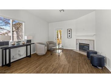 Bright living room featuring modern decor, a fireplace, and a sliding glass door at 5250 S Rainbow Blvd # 2106, Las Vegas, NV 89118