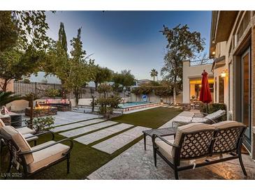 Inviting backyard retreat featuring a sparkling pool, fire pit, and comfortable lounge seating for relaxation at 7501 Midnight Rambler St, Las Vegas, NV 89149