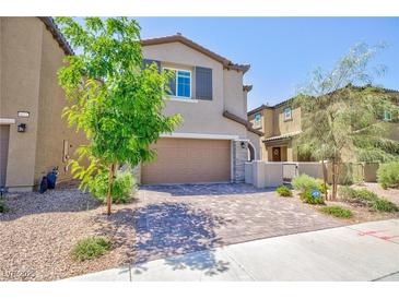 Inviting two-story home featuring a neutral color scheme, well-maintained landscaping and brick paver driveway at 8873 Howell St, Las Vegas, NV 89166